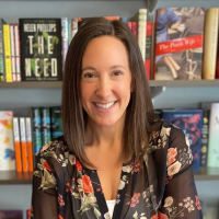 Head shot of Faye Bender, smiling in front of a bookshelf full of books